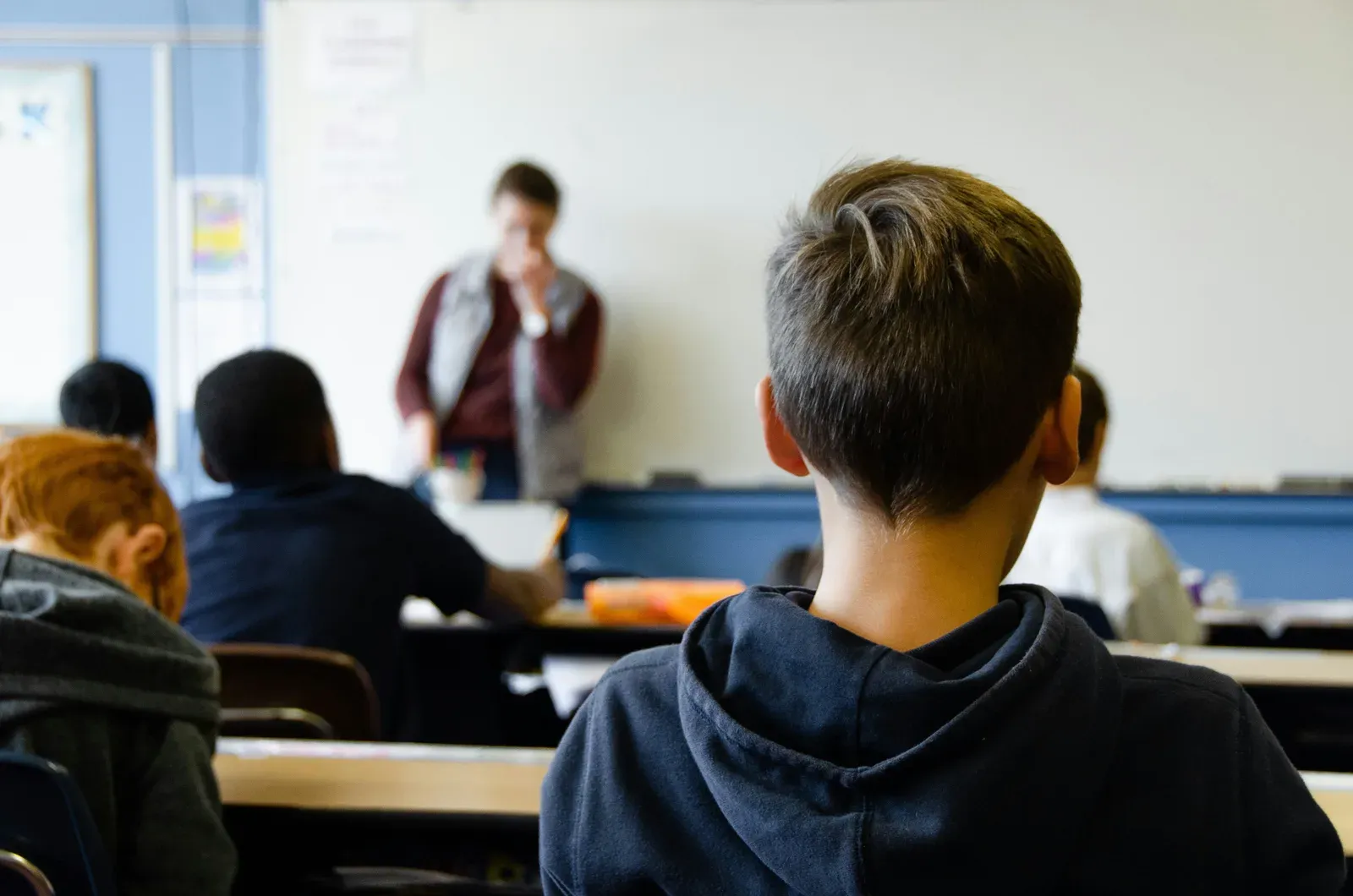 Students at their desks facing a teacher at the whiteboard